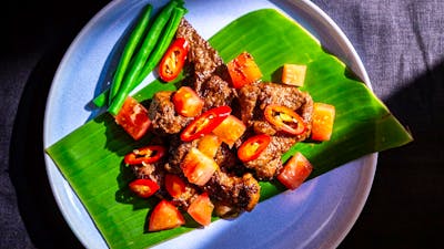 Beef Maranggi served on a banana leaf with green beans
