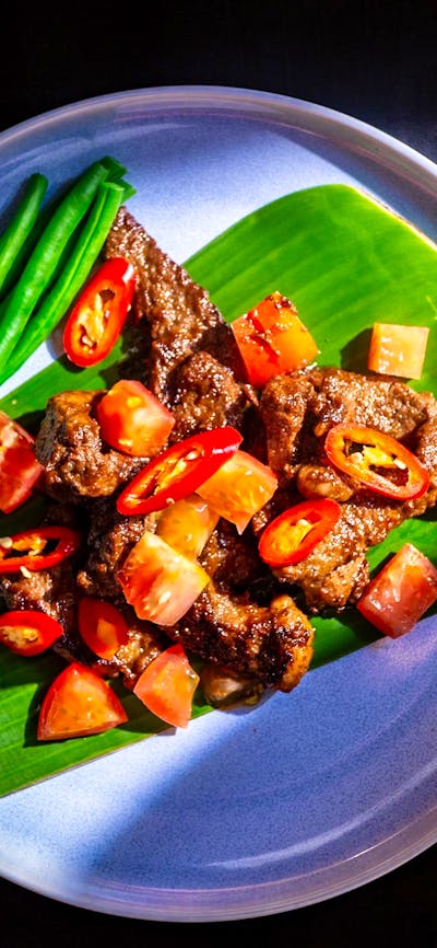 Beef Maranggi served on a banana leaf with green beans