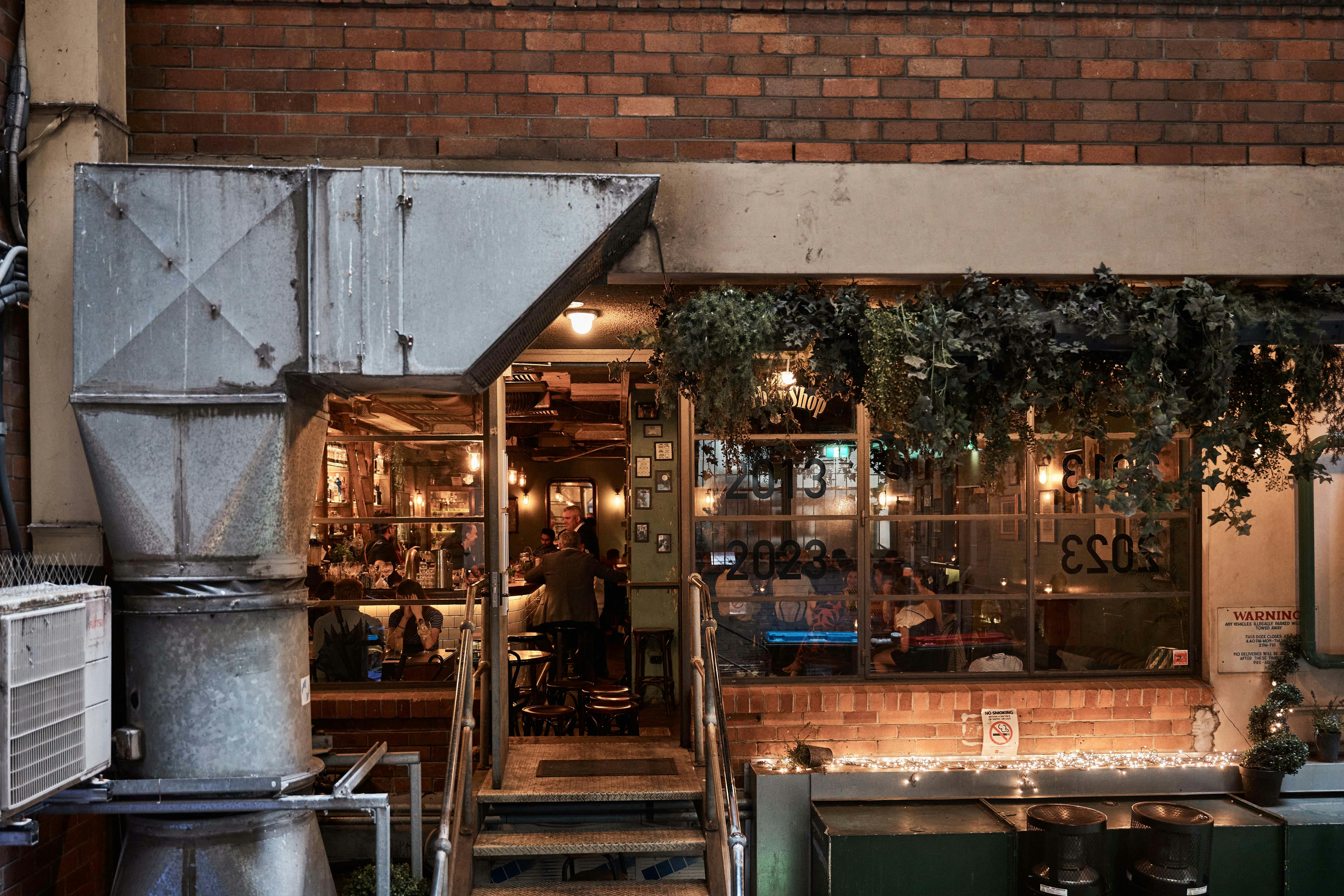 the entrance of the barbershop bar, with an industrial air conditioner vent in the foreground