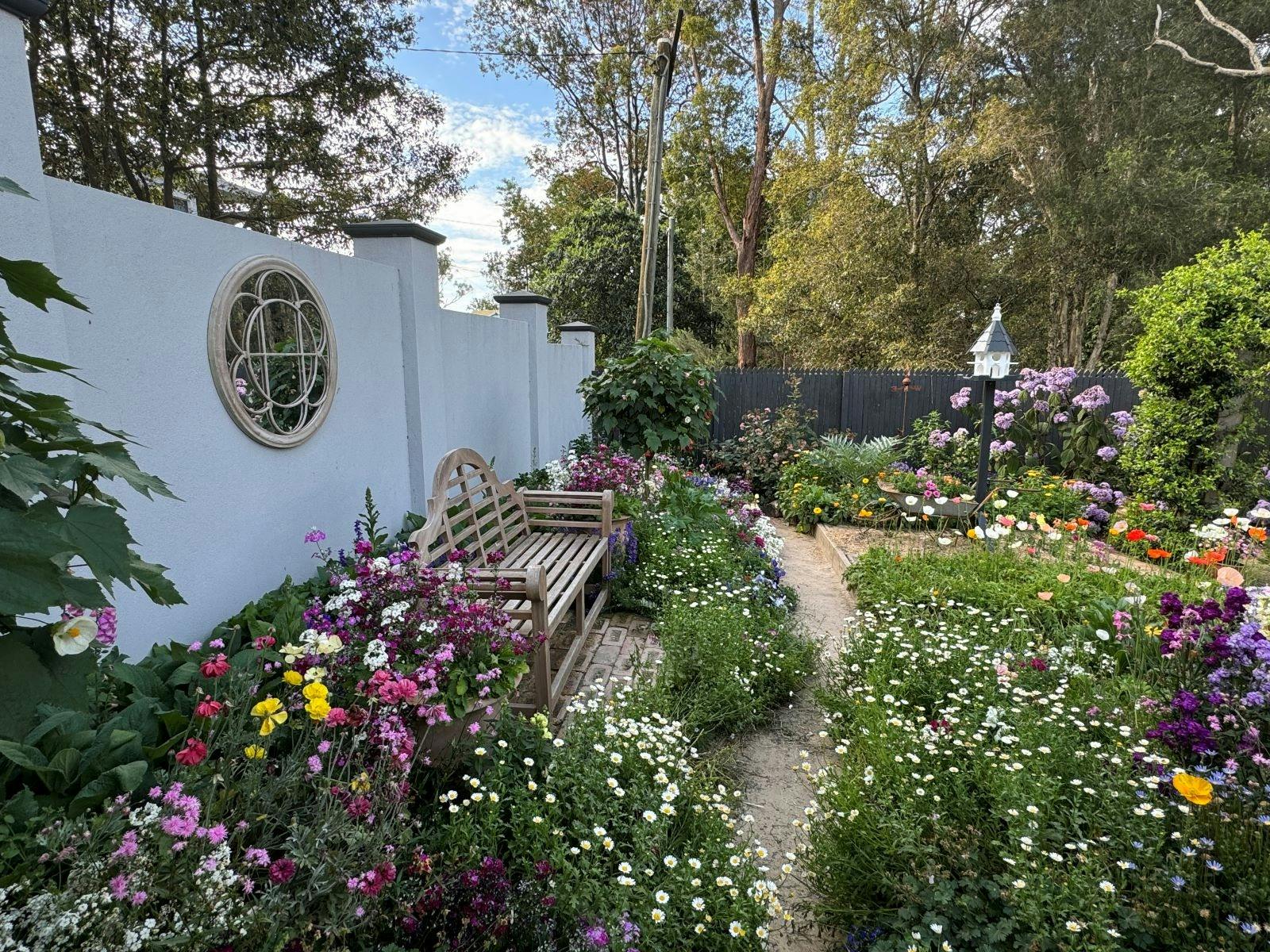 An example of an exhibition garden: pink, yellow, purple, white flowers surround a wooden chair