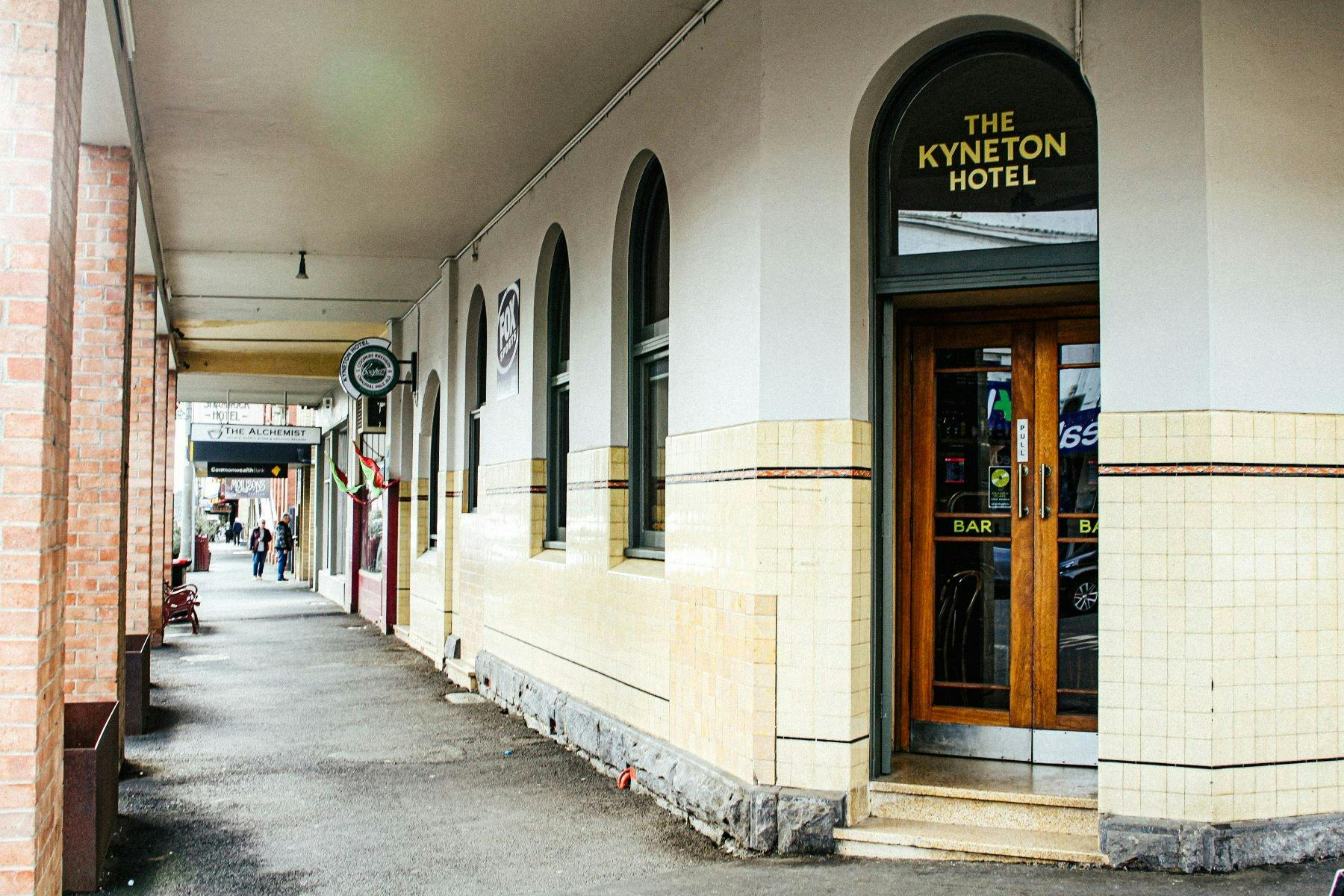 Public bar corner entry with art deco style arched door and windows.
