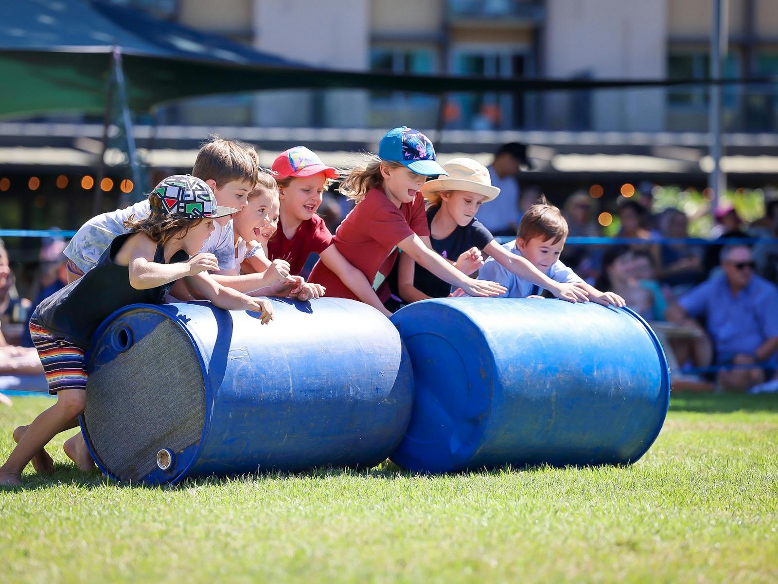 Kids pushing barrels while taking part in the outback show.