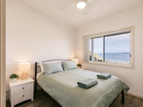 Watch the dolphins and seals swim by from your bedroom! This is one of two queen bedrooms.