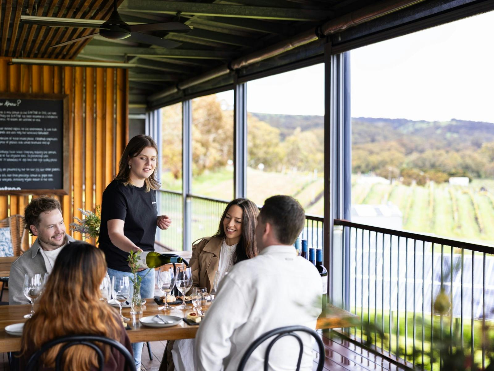 Gemtree staff member talking to four customers in a guided tasting on the deck