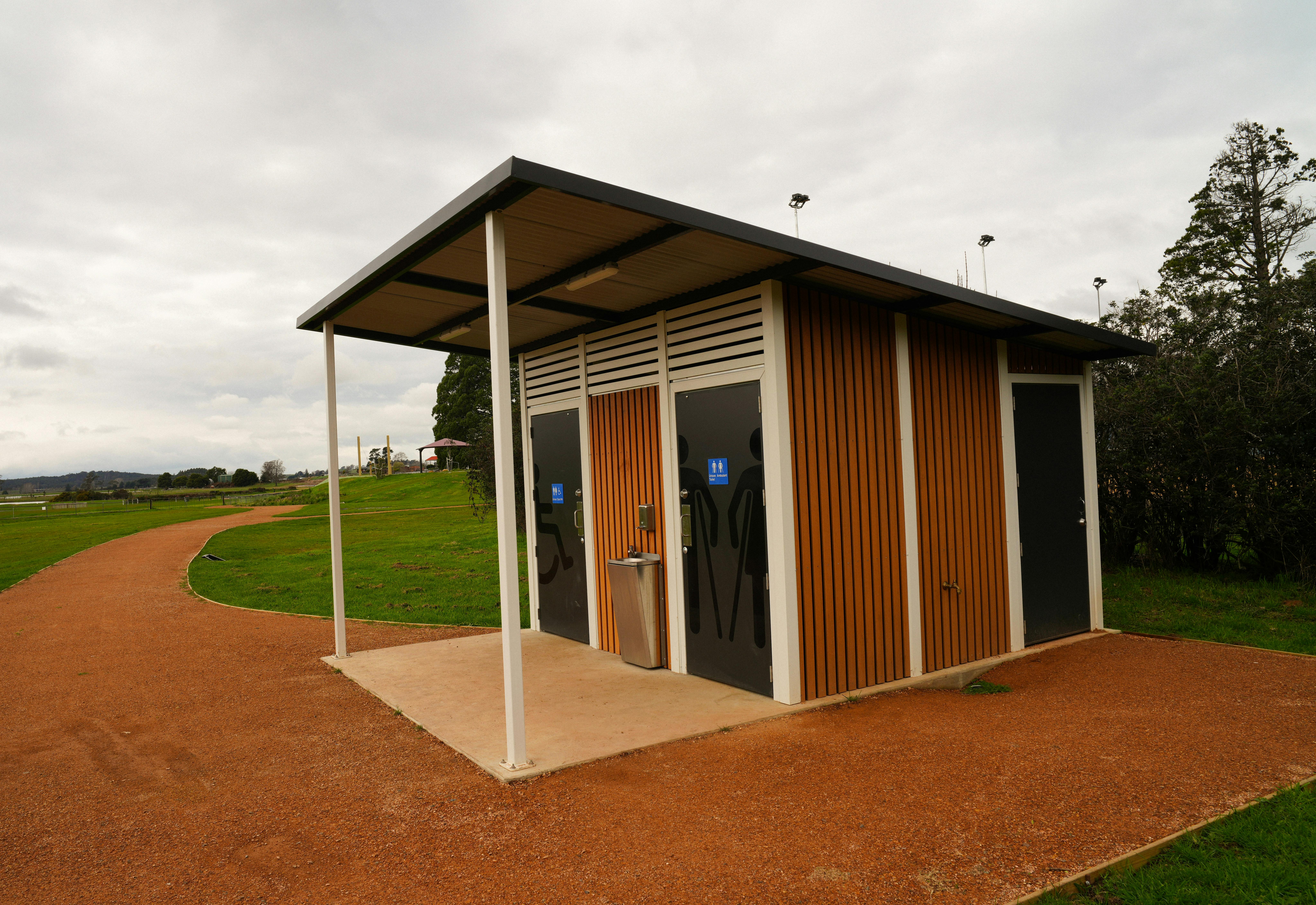 A toilet block with a bark path that leads around it.