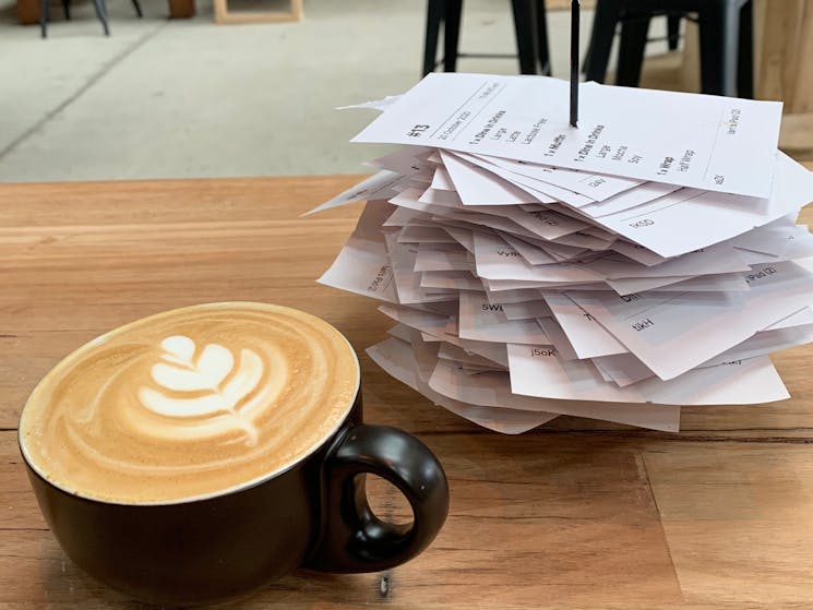 Small latte with a stack of order receipts next to it