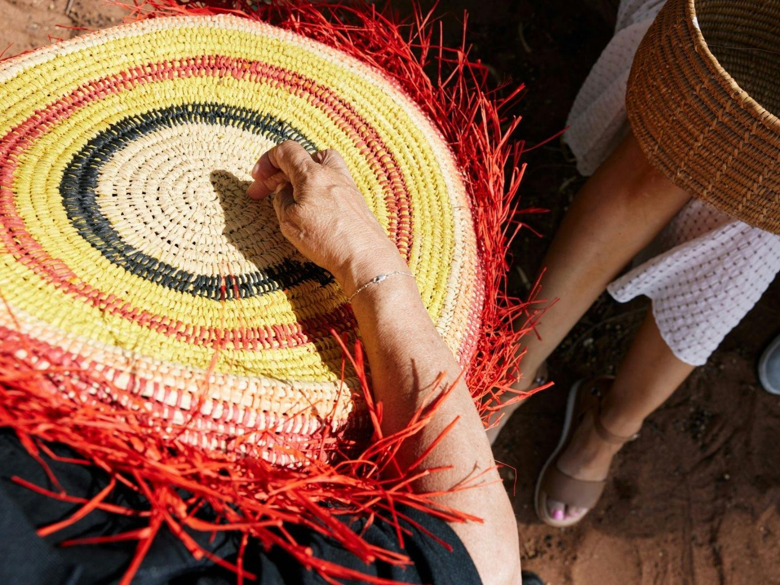 A woman holding a woven artwork