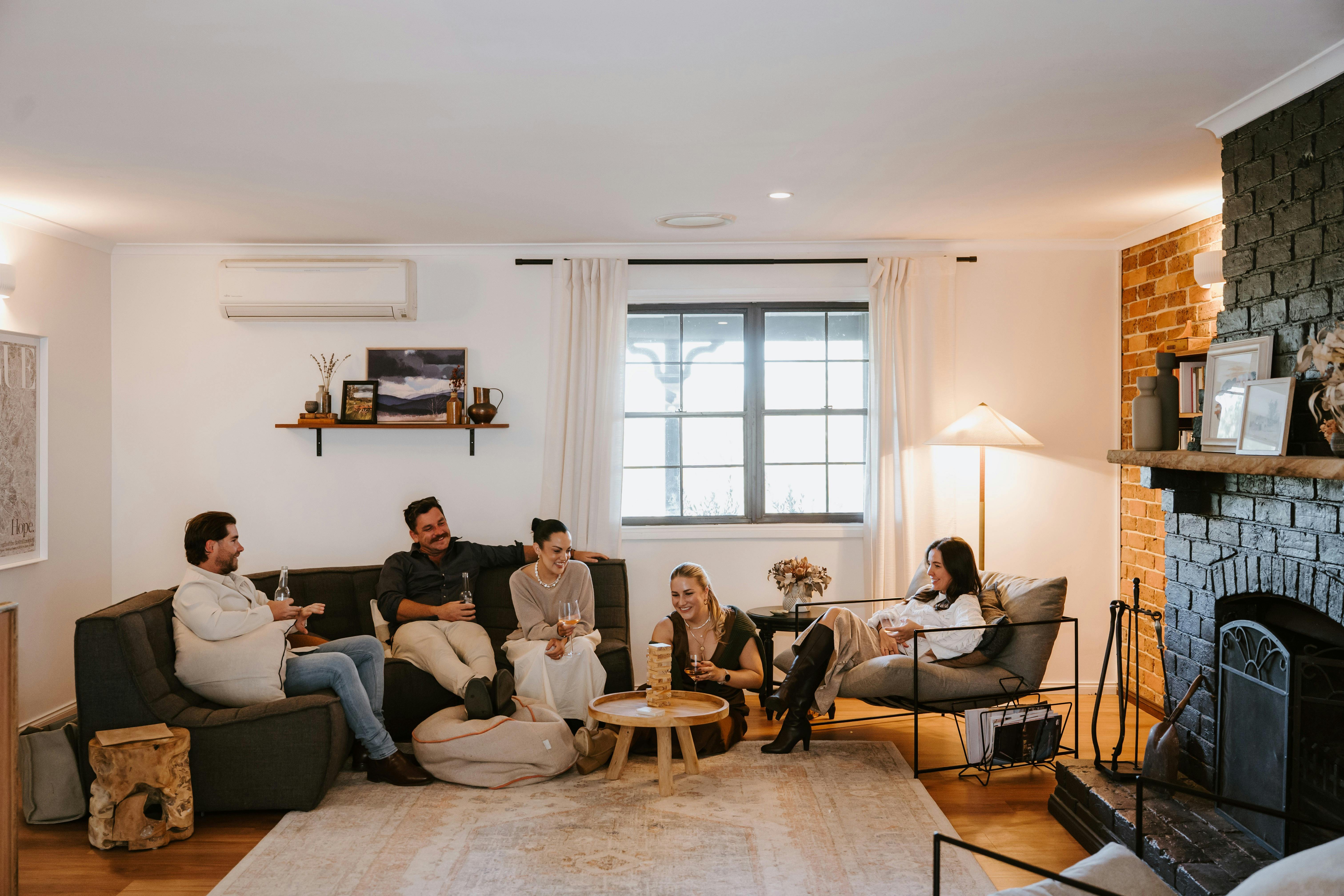 Group of friends playing a game and enjoying a drink by the fireplace