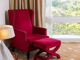 King room at Royal on the Park Hotel with red chair and view of Botanic Gardens
