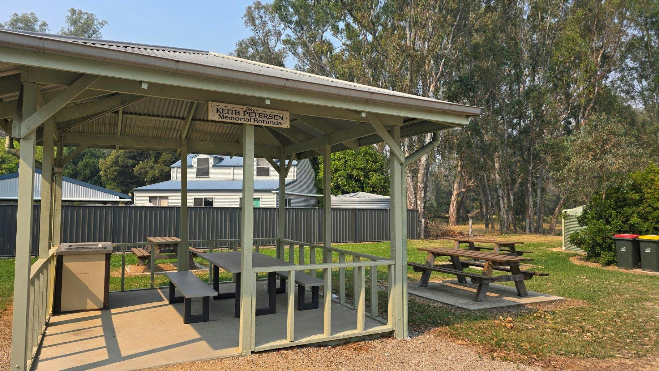 Light green rotunda area with picnic tables and green grass in the background
