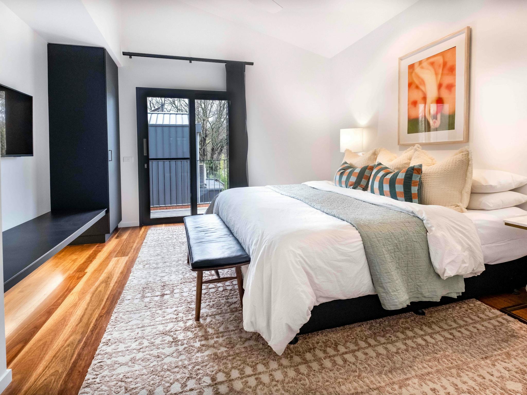 Olsen Penthouse bedroom with bed, bedside lamps, television and a wardrobe