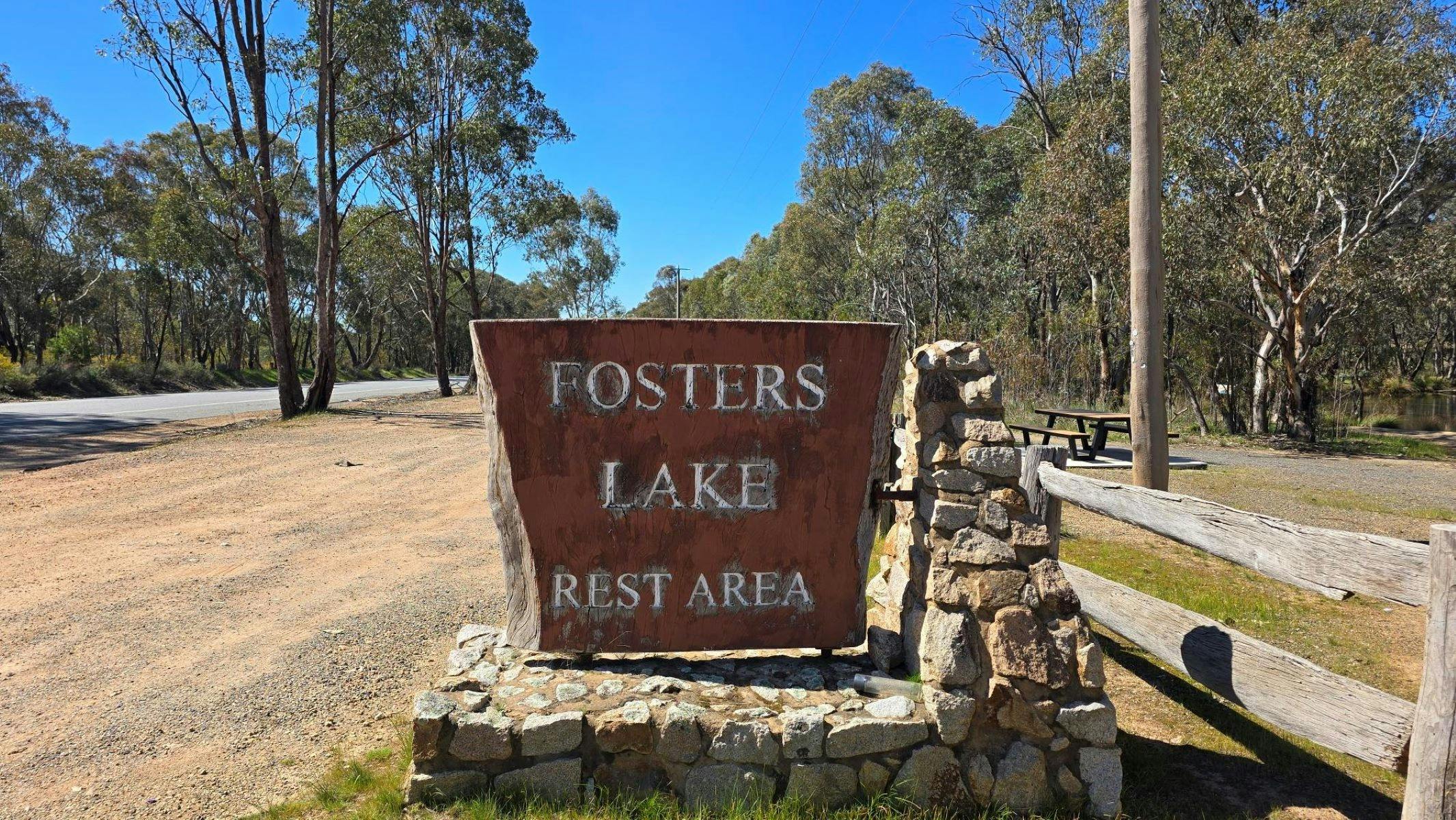 Rustic sign saying Fosters Lake Rest Area built on a stone stand