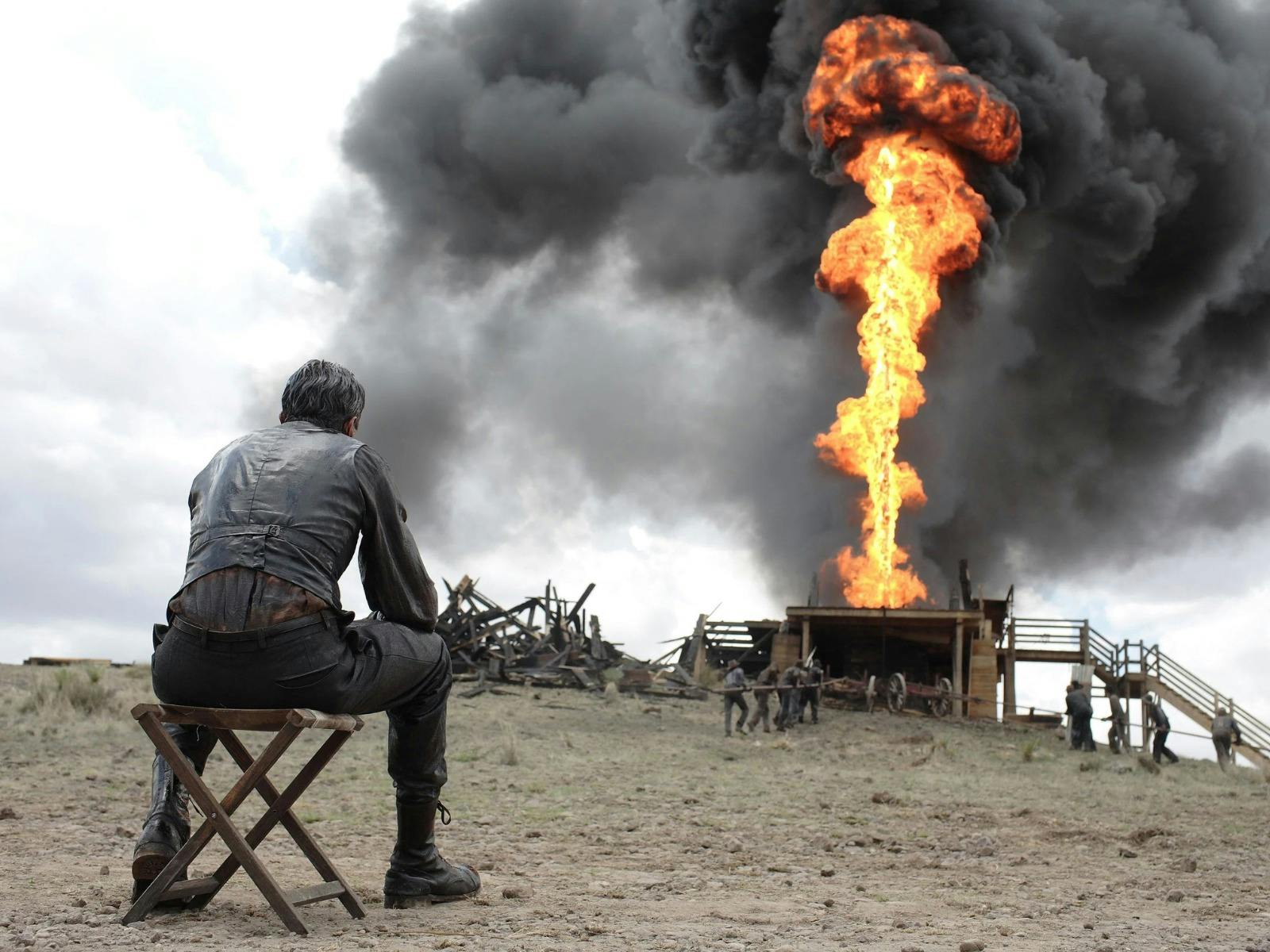 Man seated watching a firey explosion