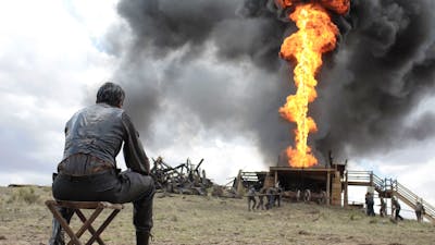 Man seated watching a firey explosion