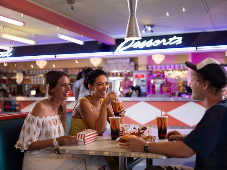 Friends enjoying pre-dinner food and drink at Retro decor at Skyline Drive In Blacktown