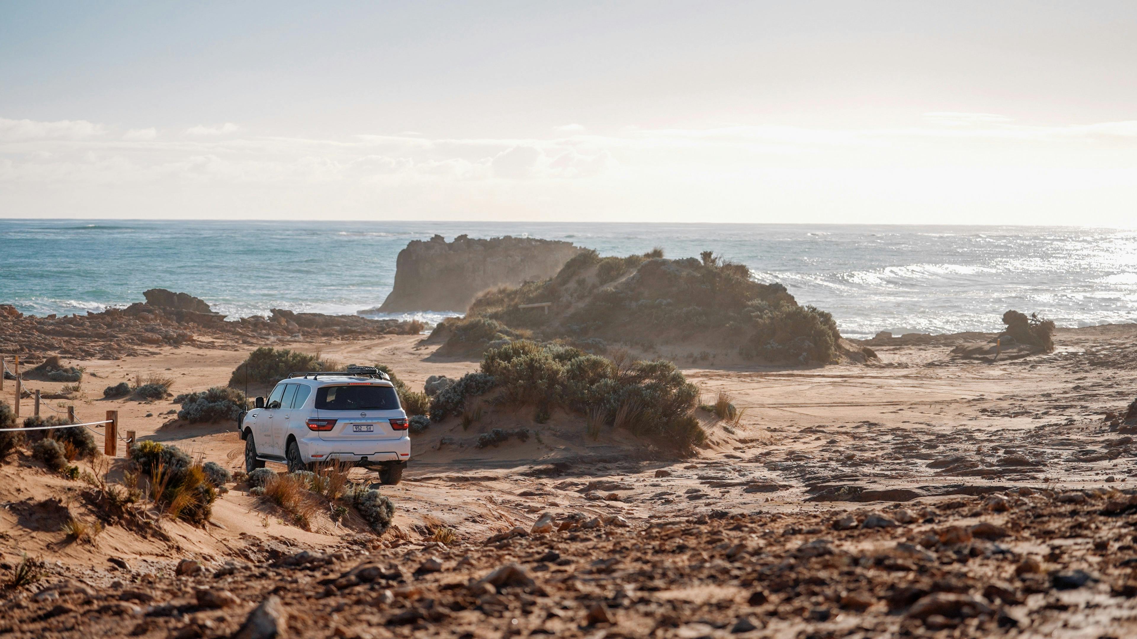 Tour Vehicle heading across a landscape of rock with ocean mist in the forground