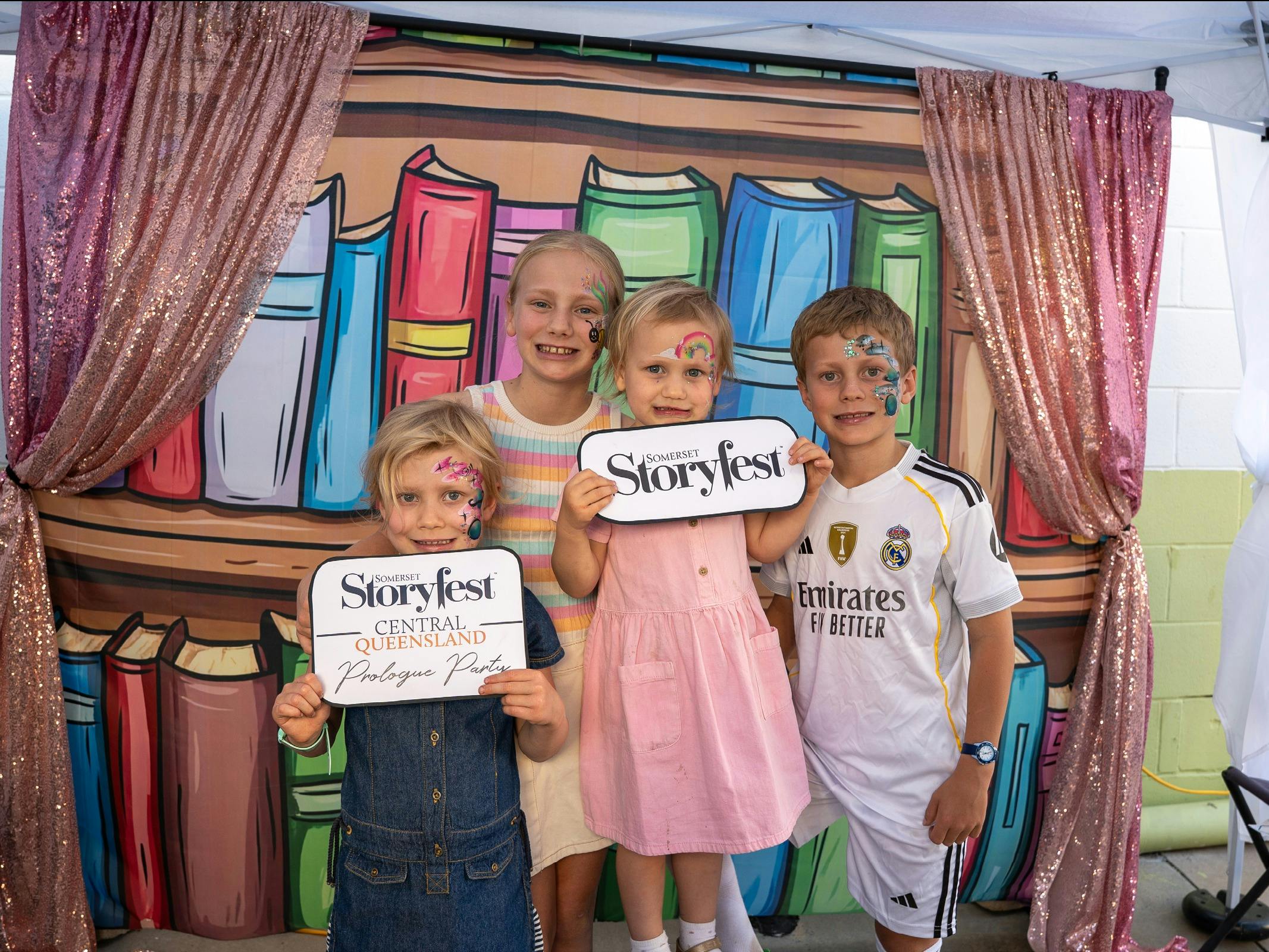 Children with face paint pose at a Storyfest Central Queensland.