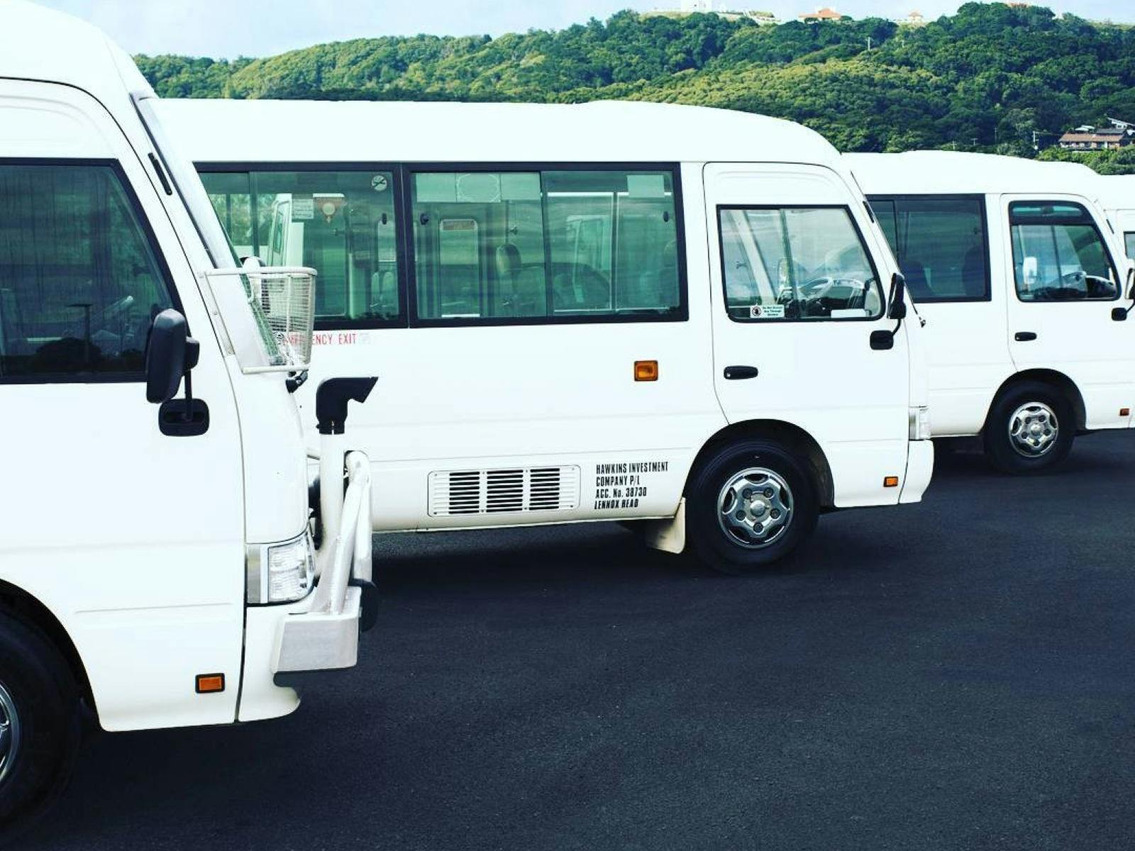 mini buses lined up with Cape Byron Lighthouse in background