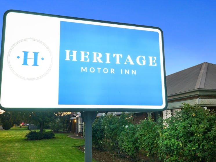 Heritage Motor Inn Front sign with Roses & grass lawn background