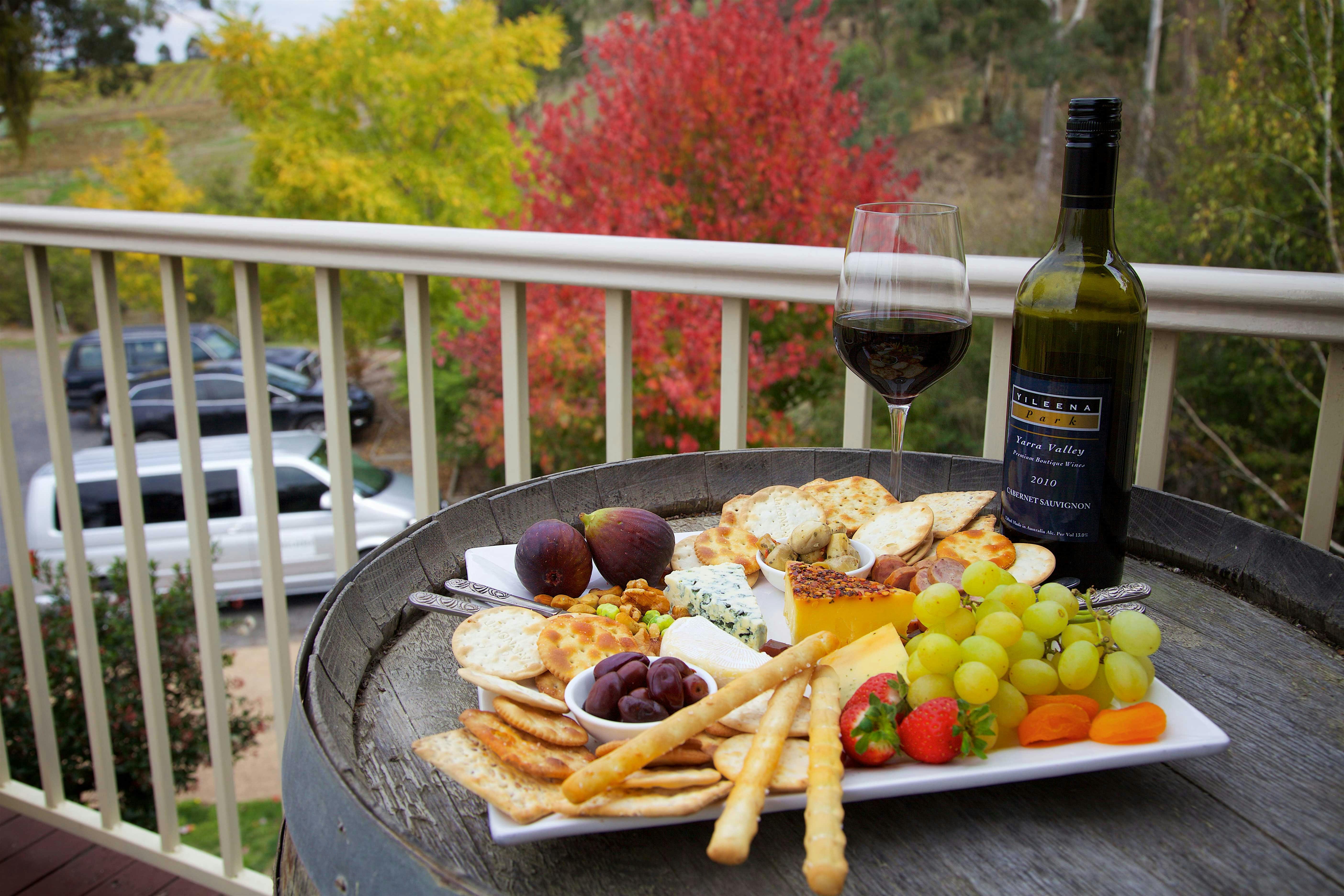 Close up photo of a delicious cheese platter and glass of quality red wine