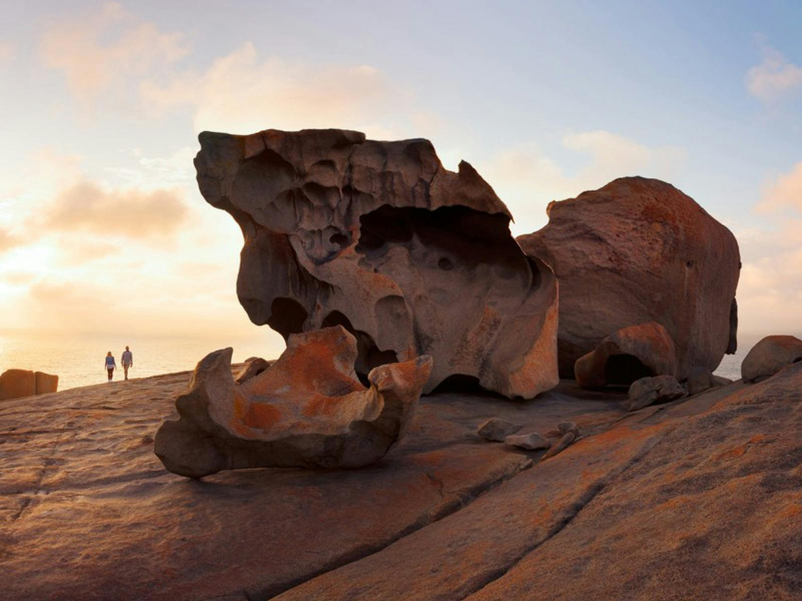 two people walk next to the remarkable rocks