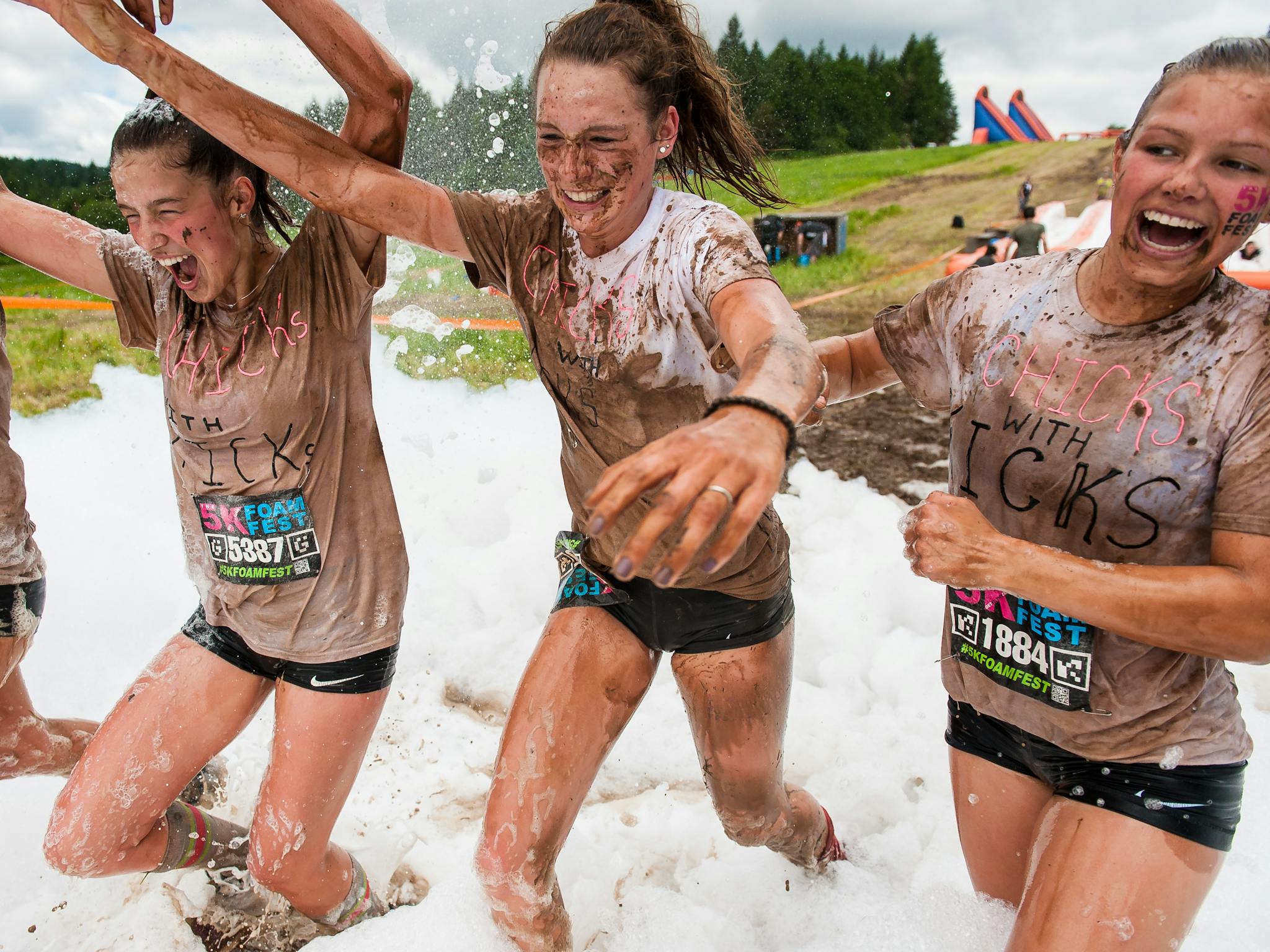 Friends crossing the foamy finish line together