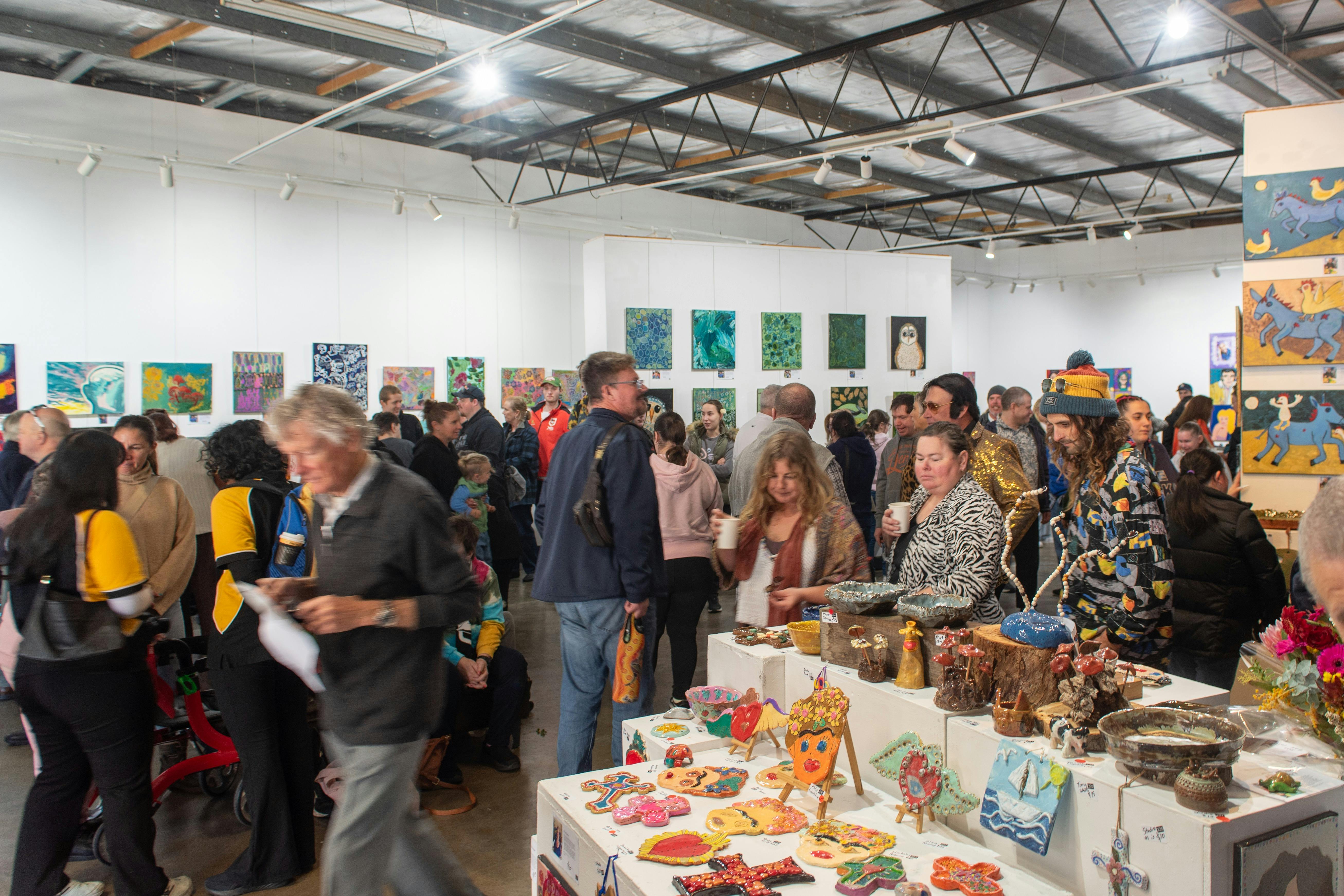 A crowd looking at different art works in an art gallery
