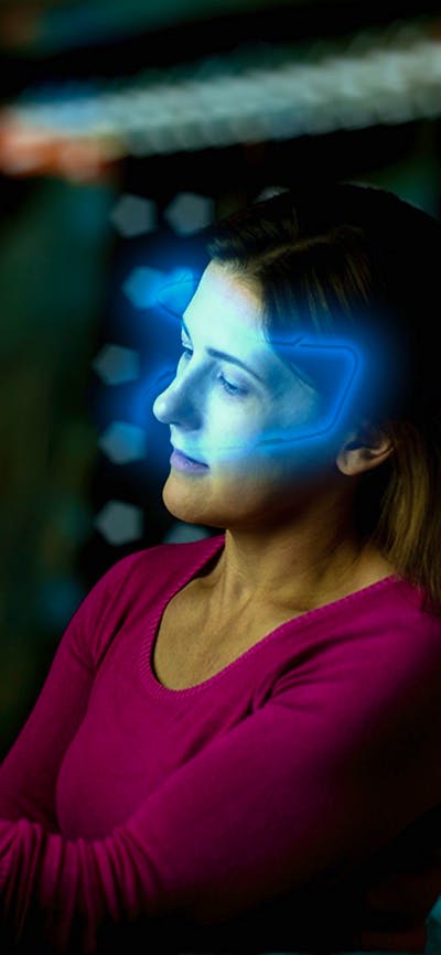 Lady with glowing VR headset looking at glowing key in escape room