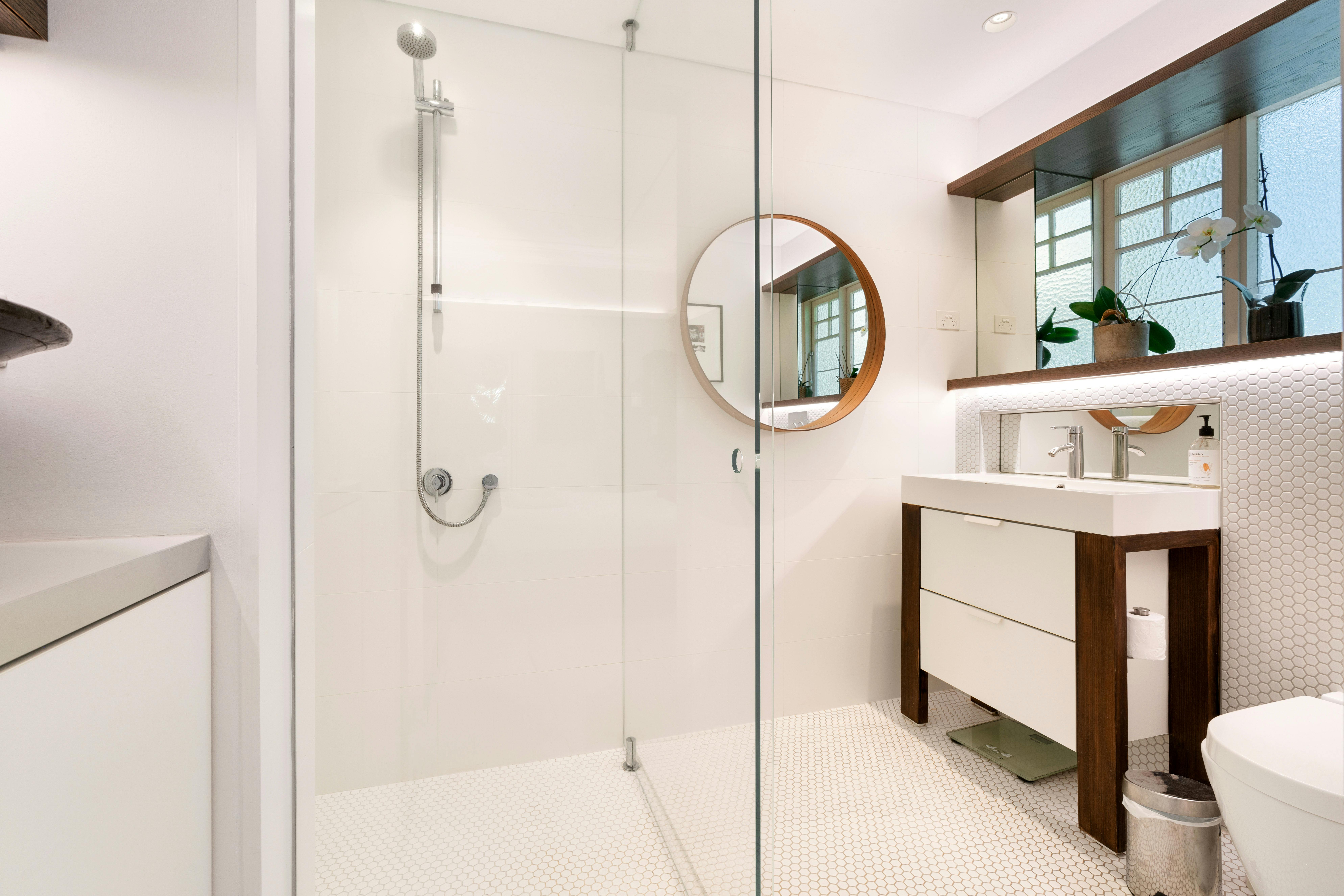 現代浴室設計時尚，配有淋浴和優雅的鏡子。