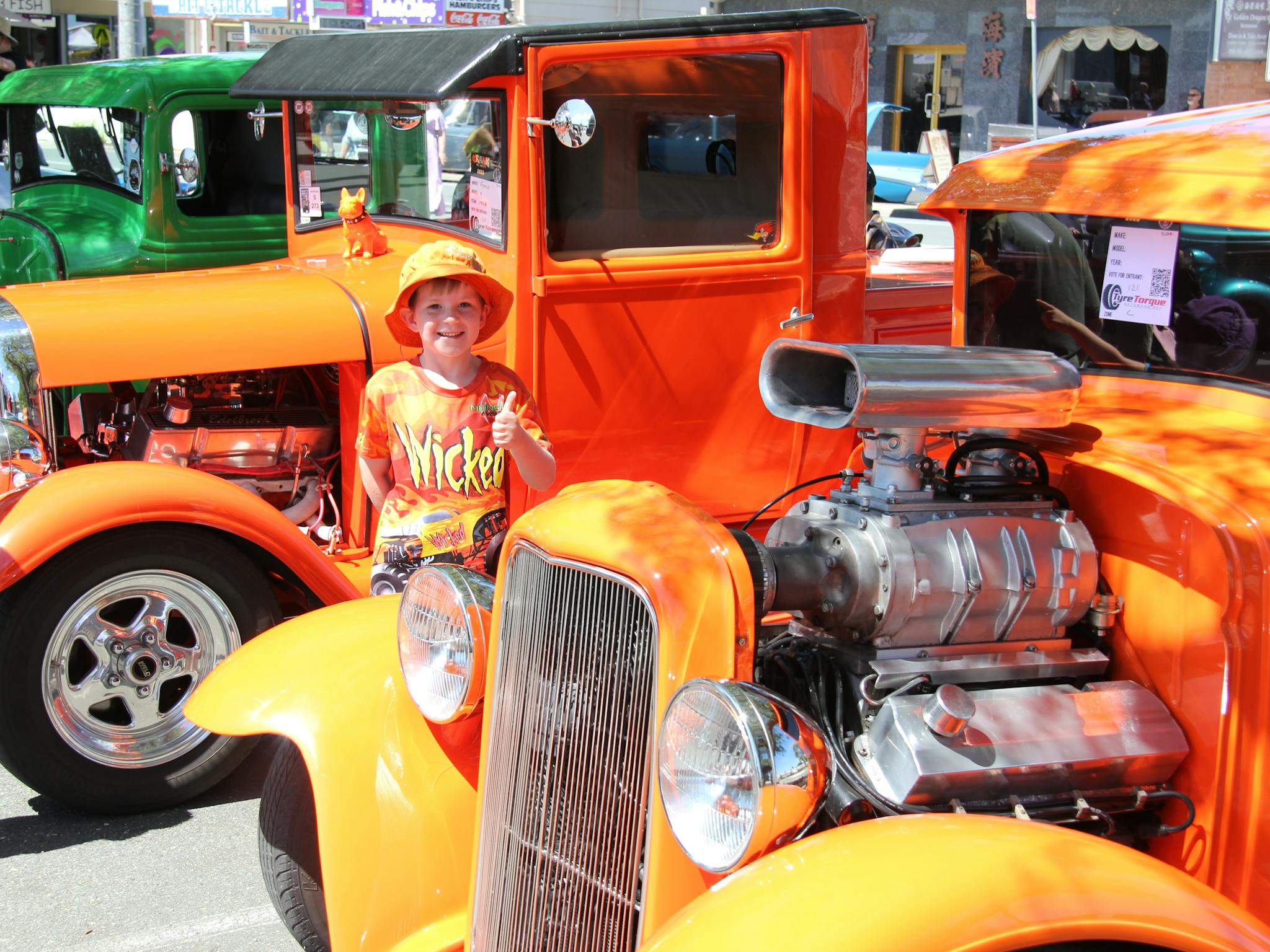 Child standing near bright Hot Rods
