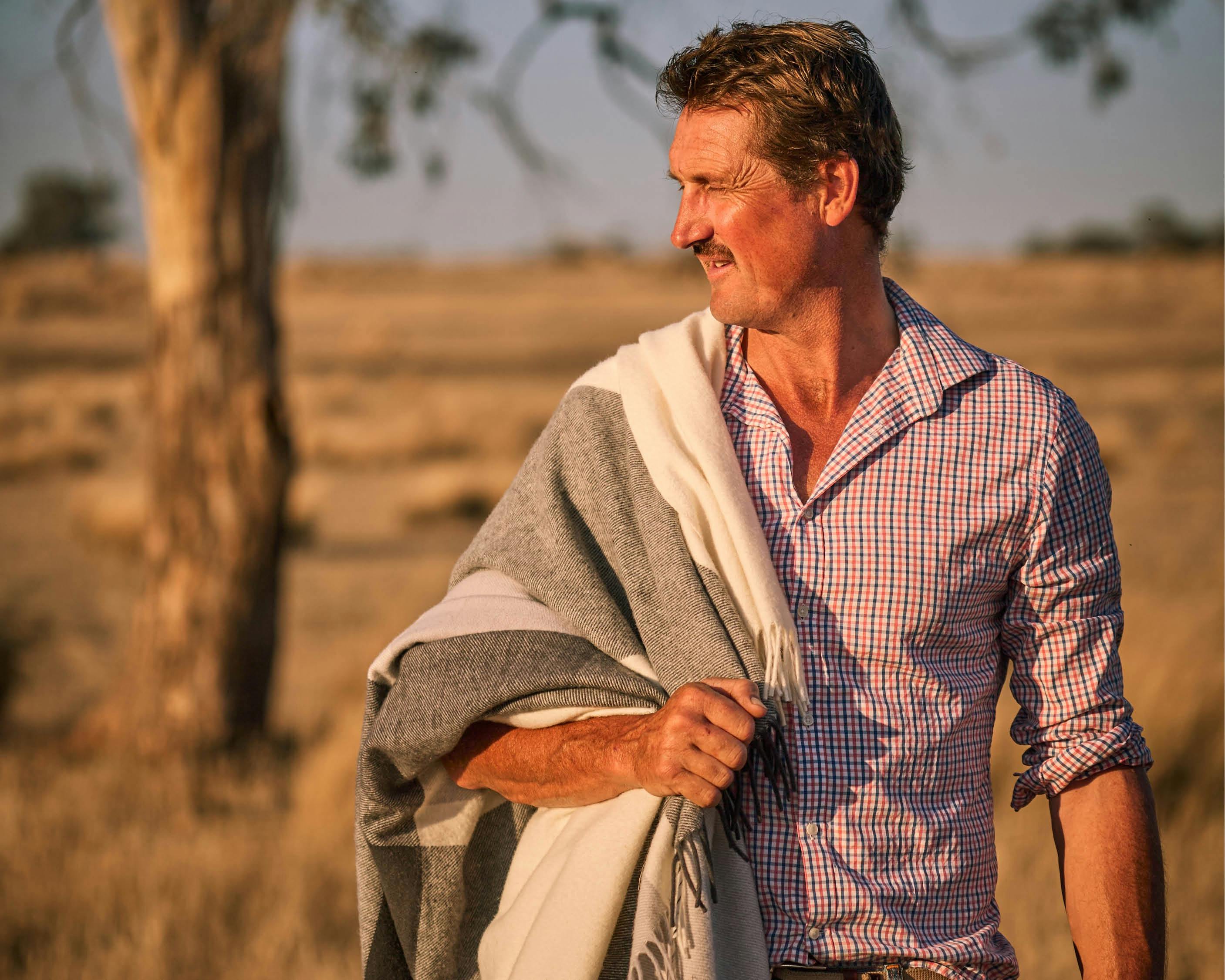 Man standing in a paddock with a Double Crossed Throw over his shoulder