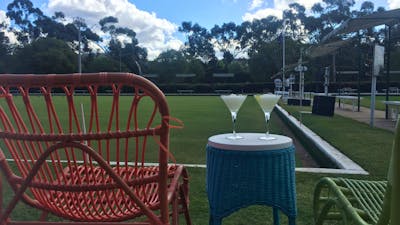 Comfortable chairs and cocktails by the greens