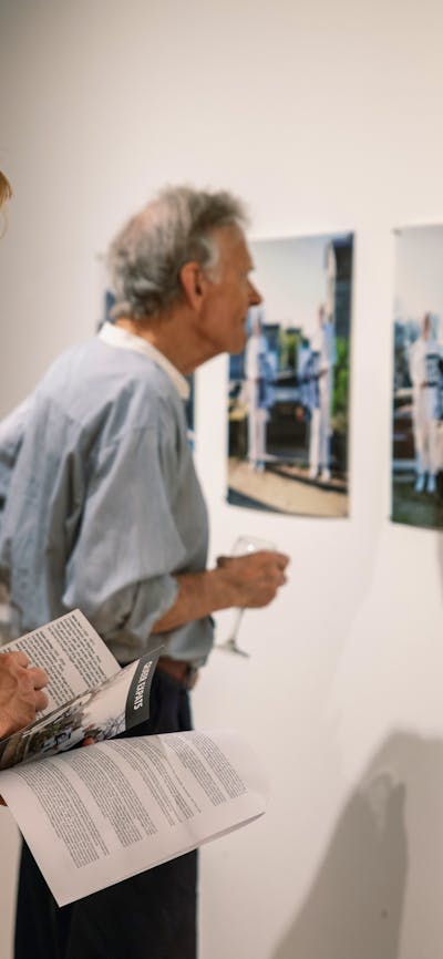 Two men look at photographs on the gallery wall