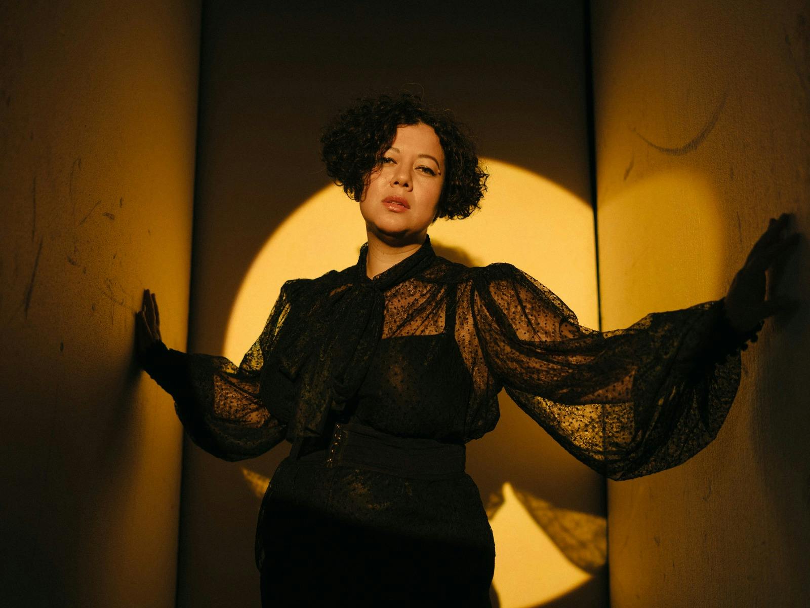 Mahalia dress in black with a spotlight on her
