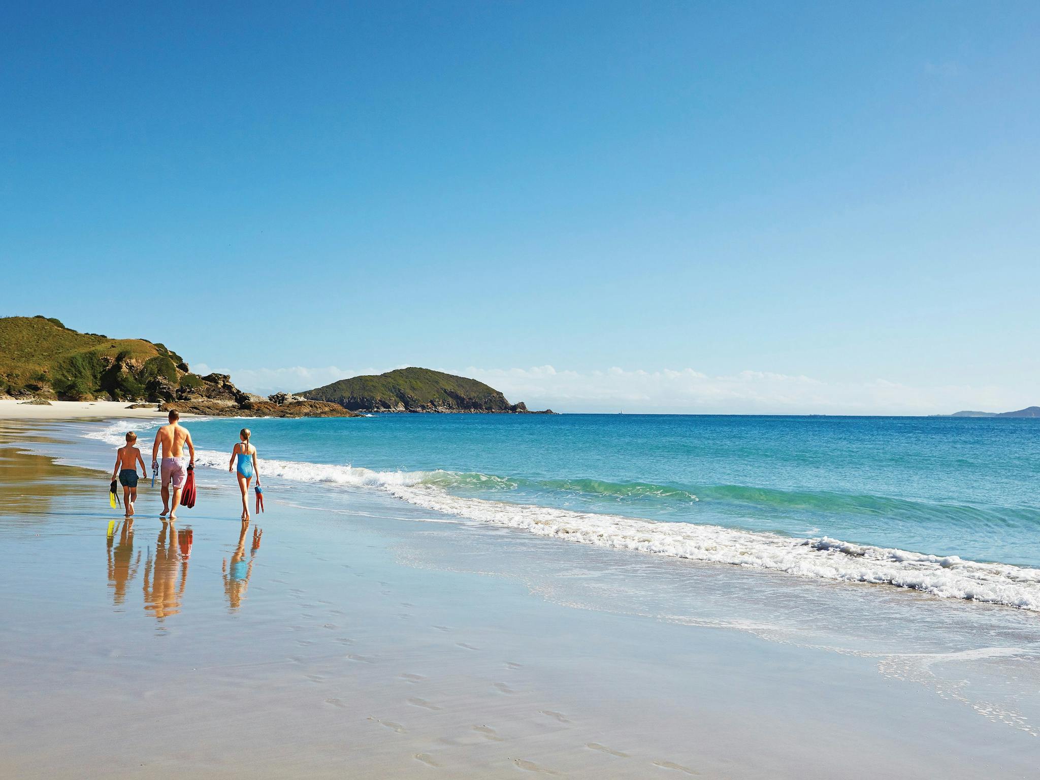 Family walking alonb beach near the shoreline, Keppel Islands Family walking alonb beach near the shoreline, Keppel Islands