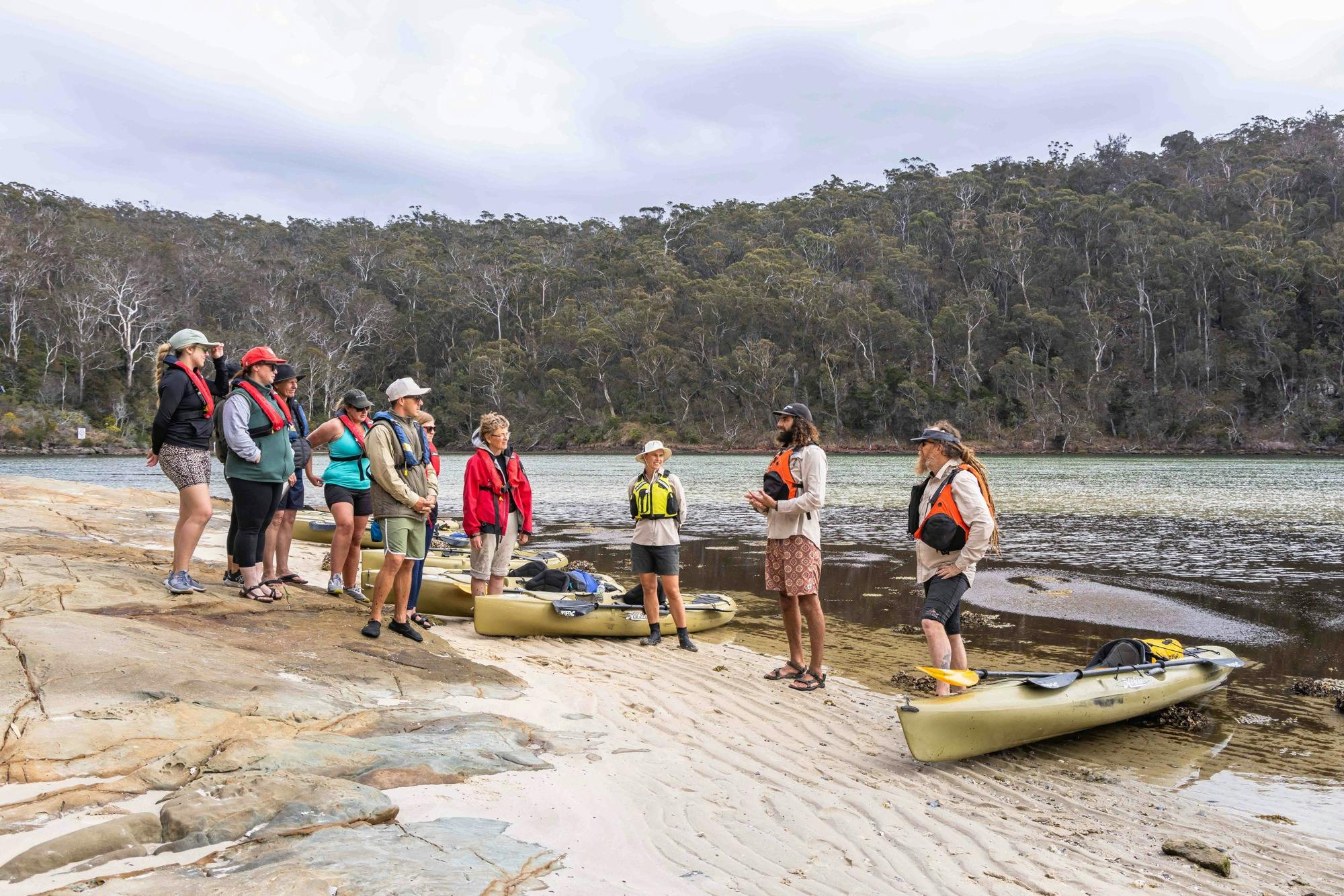 Group of guests on beach listening to guide