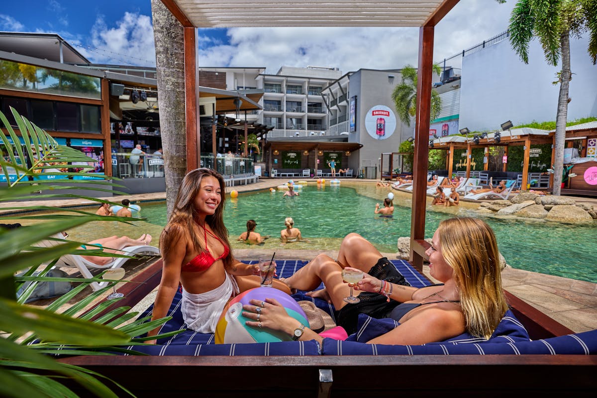 Pool area with sun loungers, cabanas and bar