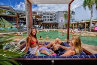 Pool area with sun loungers, cabanas and bar