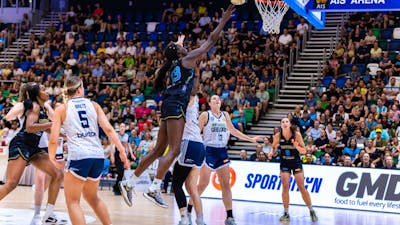 UC Capitals player driving to the basket for a layup during a WNBL game.