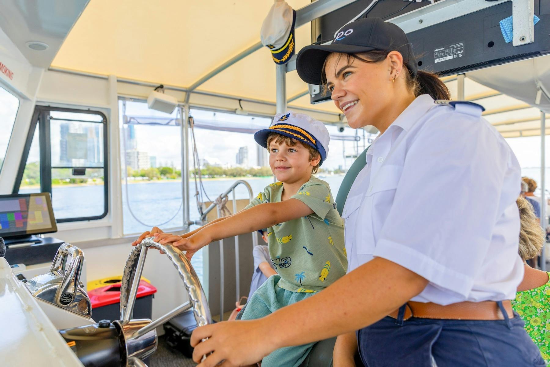 Child with the Skipper helping to steer Hopo Ferry