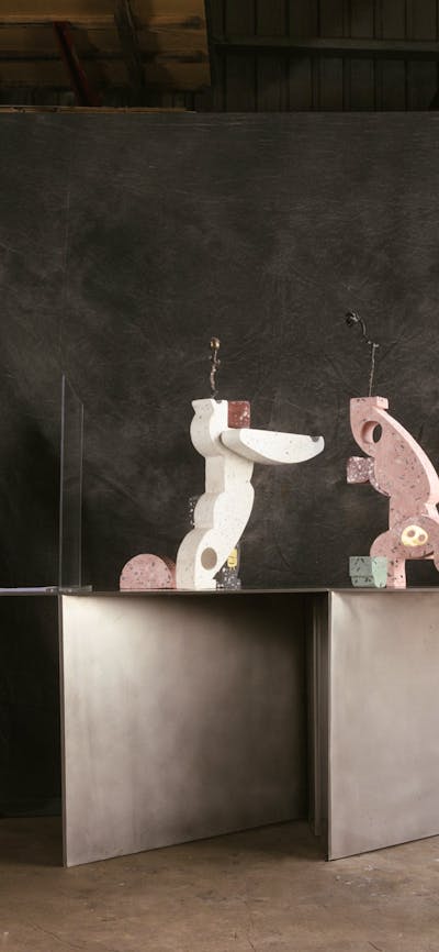 A photograph of a woman looking through a viewfinder, drawing the abstract sculptures she sees.