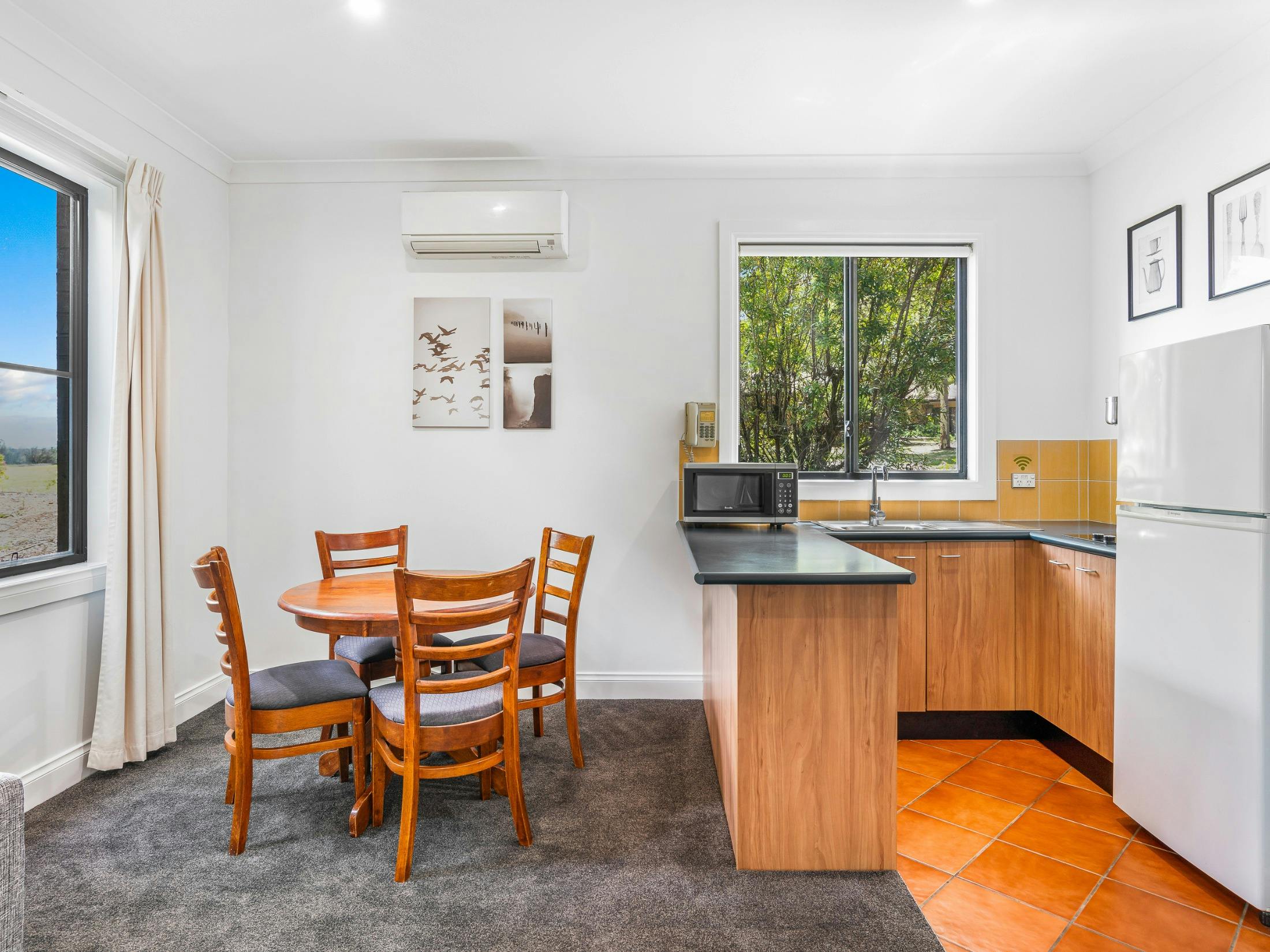 Kitchen and dining area with table, chairs, fridge and microwave