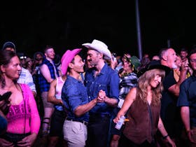 couple wearing cowboy hats dancing in crowd