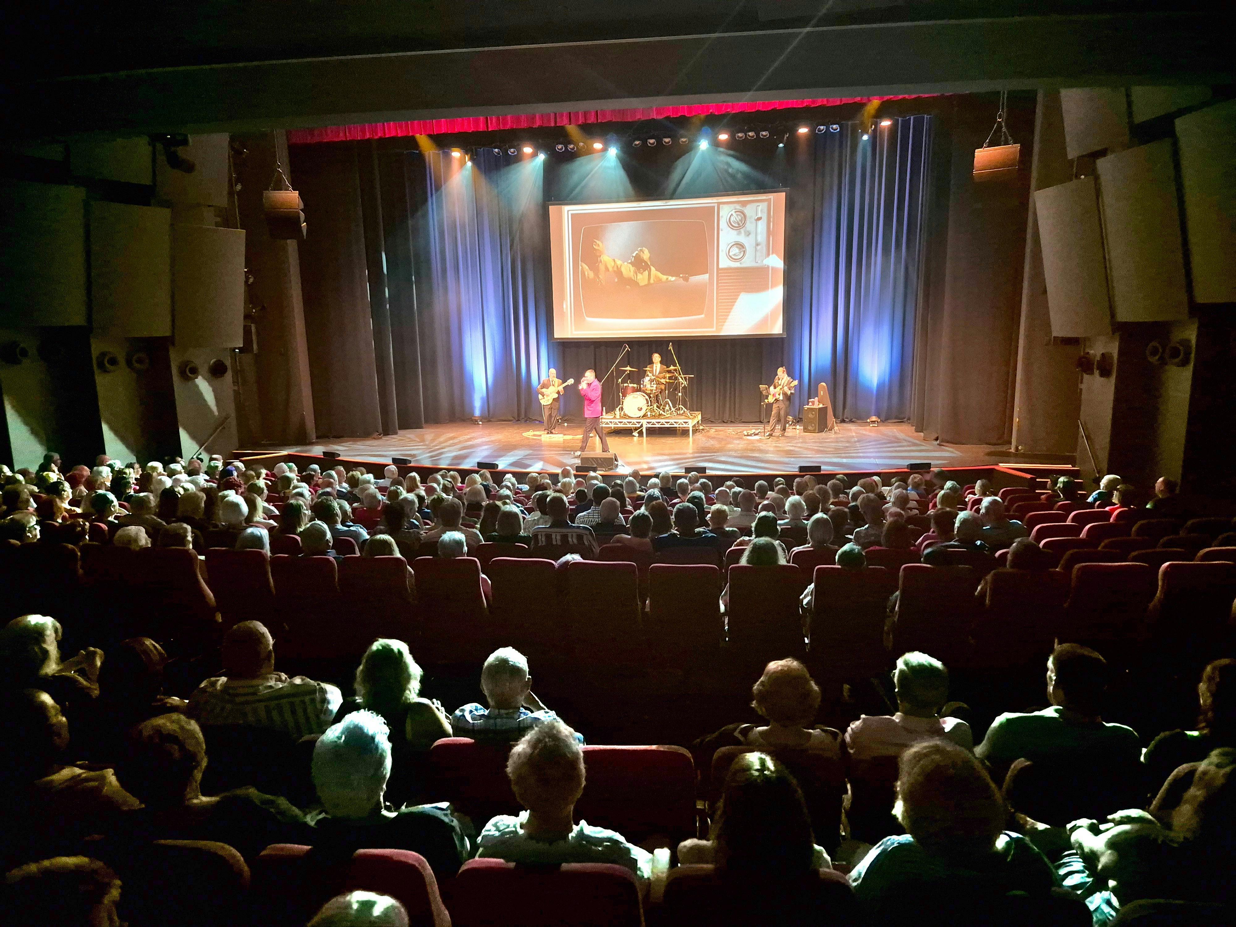 Performers on stage and a large audience
