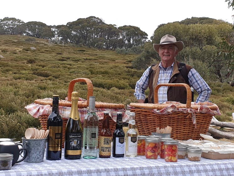 Ken Bell our storyteller, stands beside the picnic spread with a view of the walkers coming to join