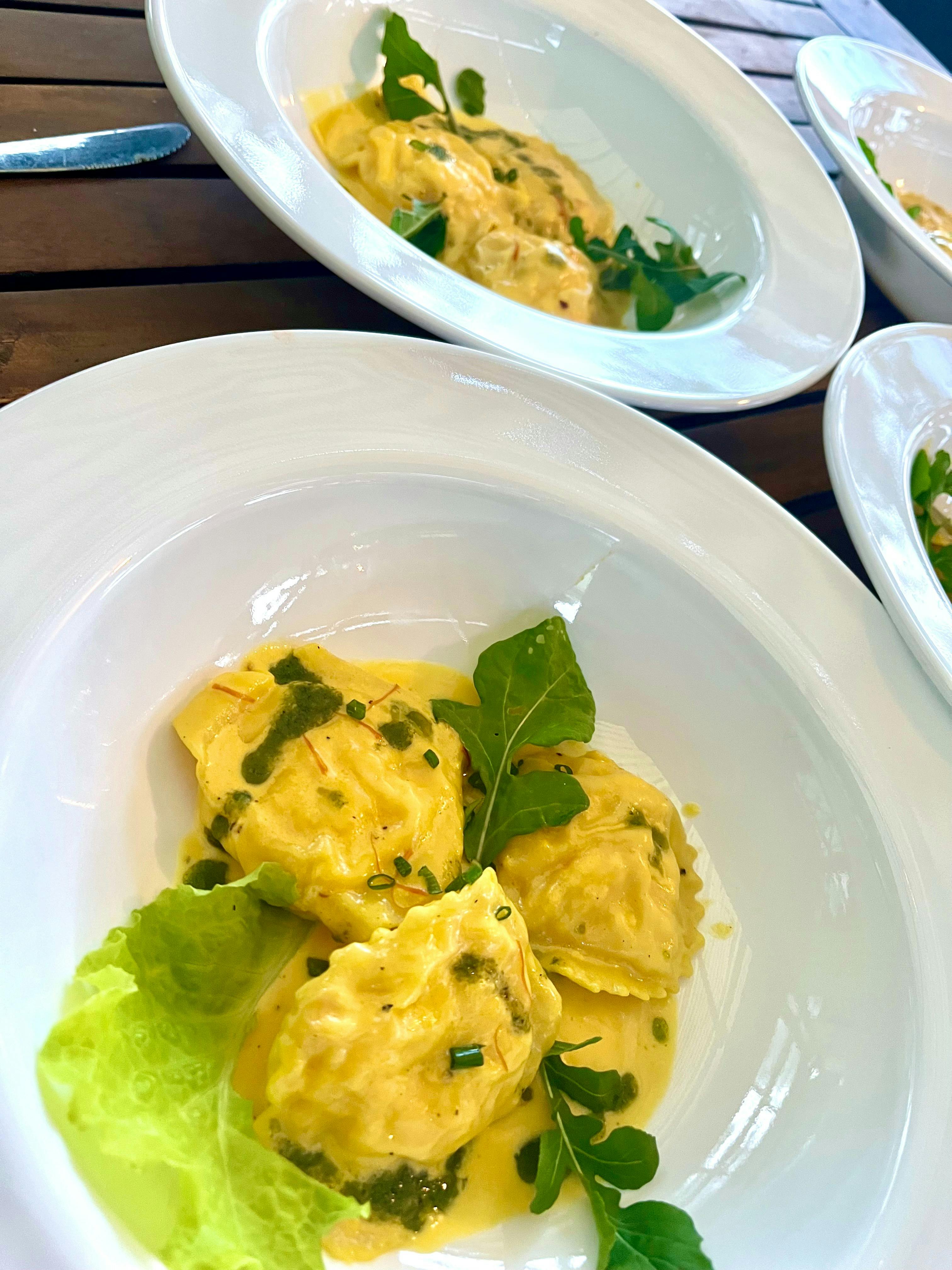 fresh prawn mousse ravioli w saffron cream sauce, basil oil and rocket