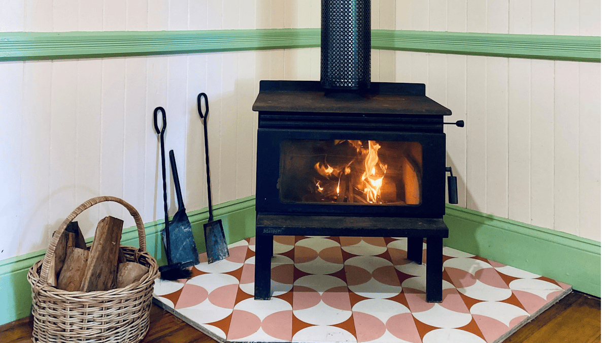 Photo of a blazing fire in a woodburner, cute tiled hearth and VJ walls