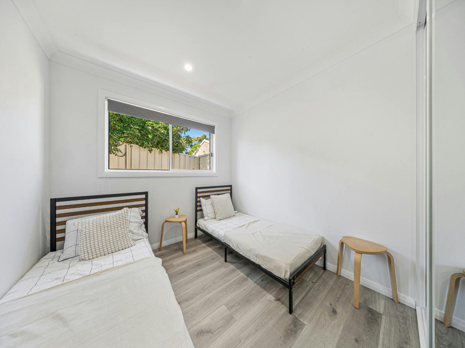 Simple and cozy bedroom with 2 single beds designed for comfort and relaxation.