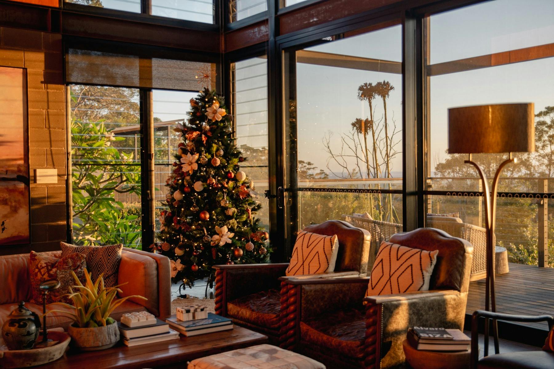 A Christmas tree in the corner of a cozy room with couches and views looking over the Blue Mountains