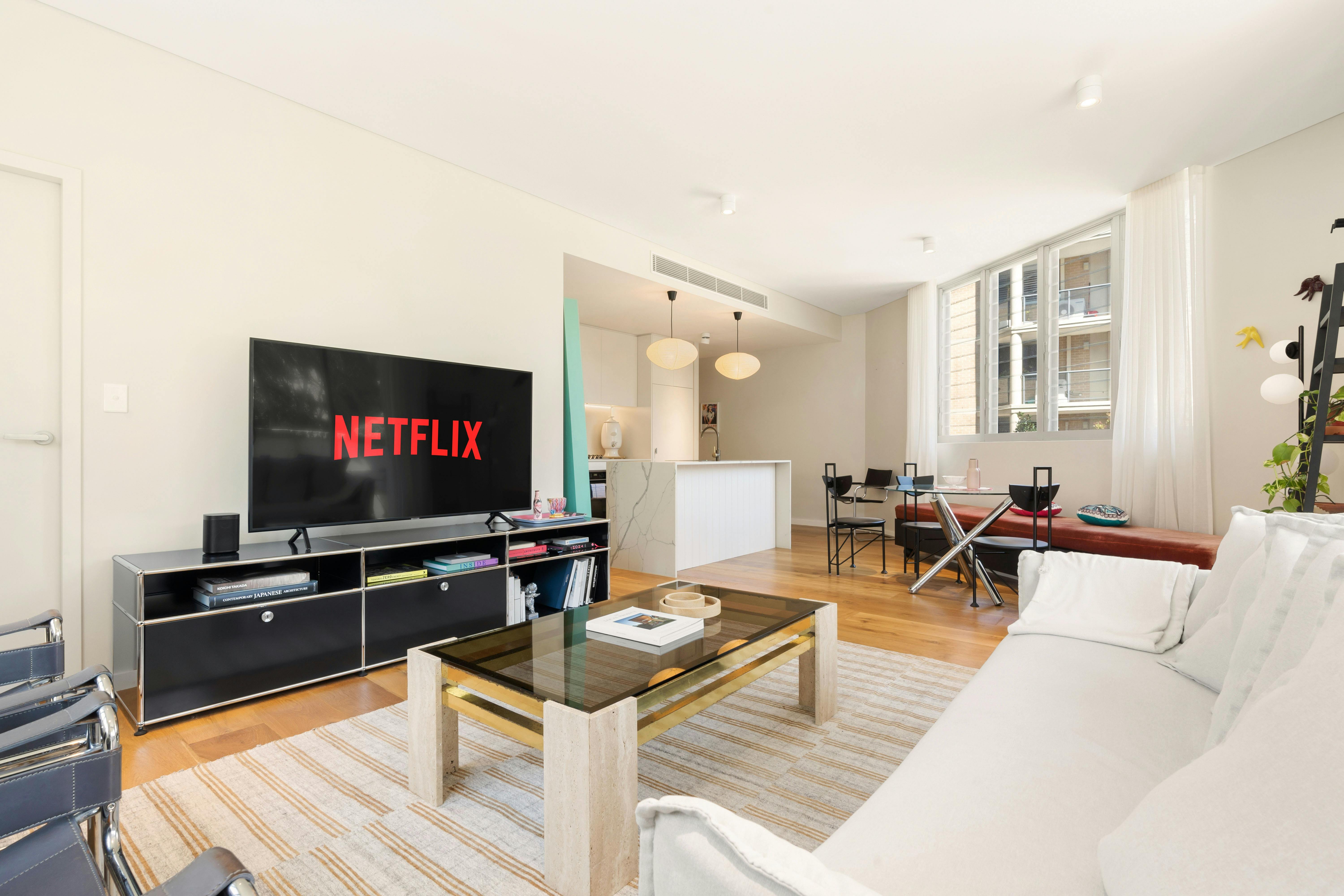 客廳配有時尚的椅子、沙發和引入陽光的大窗戶。